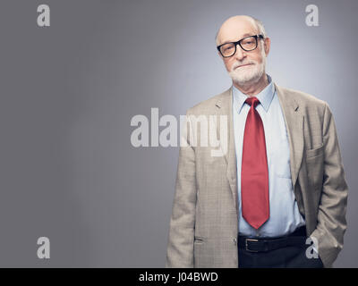 Ritratto di bello senior uomo in tuta su uno sfondo grigio con spazio di copia Foto Stock