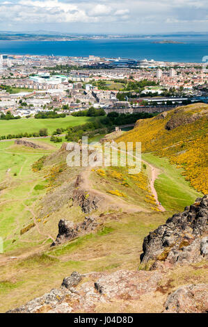 Cerca su Salisbury Crags e la periferia di Edimburgo a Portobello e Leith da Arthur Seat. Foto Stock