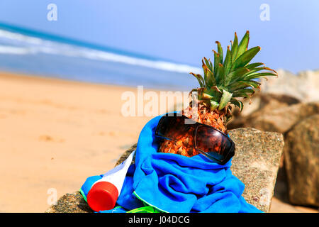 Ananas in occhiali da sole sulla spiaggia. Il concetto di un tropicale vacanza estiva. Foto Stock