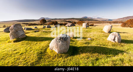 Anchient pietre permanente sulla brughiera a Machrie Moor, con uno sfondo di montagne, sulla Scozia Isle of Arran. Foto Stock