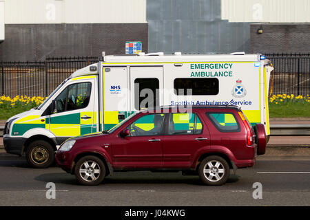 Un Servizio di ambulanza scozzese emerge ambulanza sorpasso una macchina che risponde ad un'emergenza lungo la doppia carreggiata Kingsway West a Dundee, Scozia Foto Stock