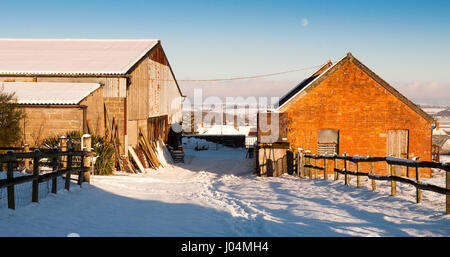 Stalbridge, England, Regno Unito - 18 dicembre 2010: Neve si trova spesso su una fattoria via e fienili nel cortile di una fattoria in Dorset's Blackmore vale la produzione lattiero-casearia district Foto Stock