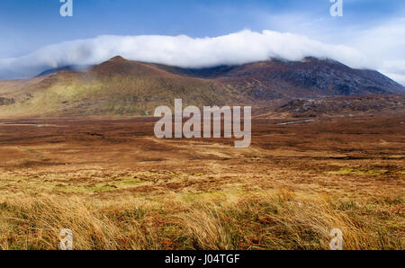 Il cloud rotoli beinn spionnaidh montagna vicino a durness nel tetro e paesaggio arido del telecomando lontano Nord delle Highlands della Scozia. Foto Stock