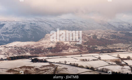 In inverno la neve si trova su campi e montagne intorno a Castlerigg Stone Circle in Inghilterra del Lake District. Foto Stock
