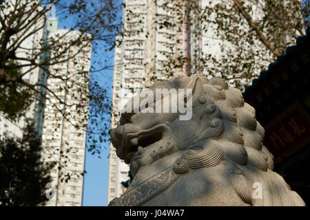 Cinese feroce creatura mitico dominato da alti edifici di appartamenti a wong tai sin temple, hong kong. Foto Stock