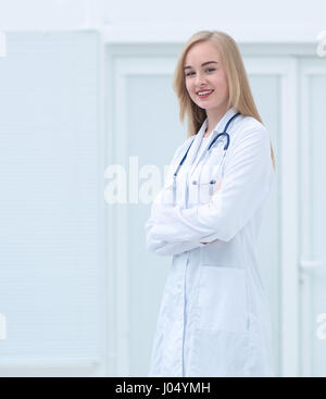 Bella giovane medico donna sorridente con fiducia in piedi alla clinica Foto Stock