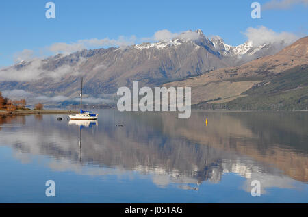 Barca su un lago nella riflessione delle montagne del film del Signore degli Anelli ubicazione, Glenorchy, Nuova Zelanda Foto Stock