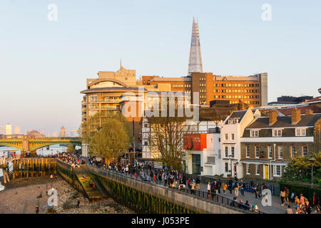 Per coloro che godono di una posizione soleggiata di sera su Londra il South Bank di fronte al Globe Theatre con la Shard in background. Foto Stock