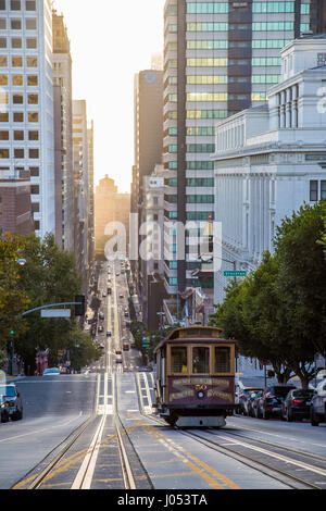Visualizzazione classica della storica Funivia equitazione sulla famosa California Street in beautiful Golden. La luce del mattino al sorgere del sole in estate, San Francisco, Stati Uniti d'America Foto Stock