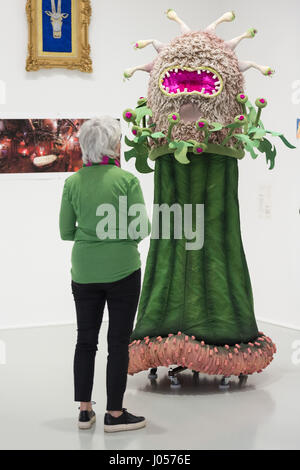 Hannover, Germania. Decimo Apr, 2017. Un visitatore guarda un fiore il costume da lo spettacolo teatrale "Komm in meinen Wigwam' dall'anno 2014/15 presso il Teatro Dortmund, alla mostra del regista e autore Wenzel Storch al Sprengel Museum di Hannover, Germania, 10 aprile 2017. La mostra 'Wenzel Storch - il ferro caldo di memoria può essere vedere dal 12 aprile al 16 luglio 2017. Requisiti, schizzi, disegni, fotografie e sequenze di film dell'artista saranno esposti. Foto: Sila Stein/dpa/Alamy Live News Foto Stock