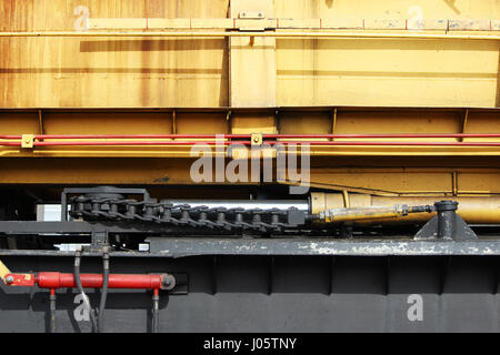 Il dispositivo di un caricatore di colore giallo sulla ferrovia. Sistema idraulico. Foto Stock