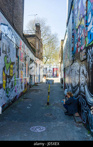 Un vicoletto principali off Brick Lane nella zona est di Londra è coperto con la street art e graffiti. Foto Stock