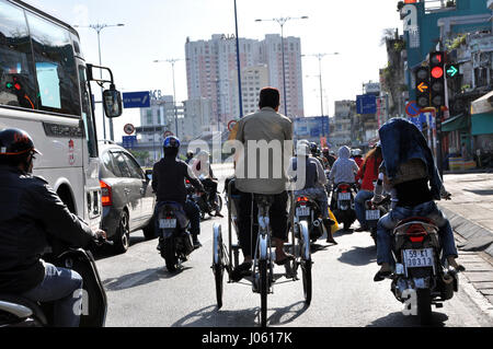 HO CHI MINH, VIETNAM - 15 febbraio 2013: turistica prendendo un tour con una classica vietnamita, rickshaw tuk tuk a Saigon Foto Stock