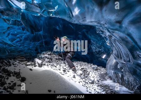 Islanda: Un fotografo braves le grotte per ottenere foto perfette. Questi cold-come-esploratori di ghiaccio sono stati-disposti a sacrificare al fine di catturare queste magnifiche grotte di ghiaccio prima che si sciolga. Immagini sorprendenti hanno rivelato ice-cool turisti britannici di refrigerazione all'interno il più lungo ghiacciaio d'Europa - pur essendo a rischio di allagamento. La spettacolare collezione di immagini mostrano gli esploratori sfidando le temperature di congelamento a salire, fotografia e persino calata all'interno del gelido cliff i lati. Un'altra immagine mostra uno dei visitatori sulle ginocchia che figurano a pregare accanto a una cascata di ghiaccio fuso. Foto Stock