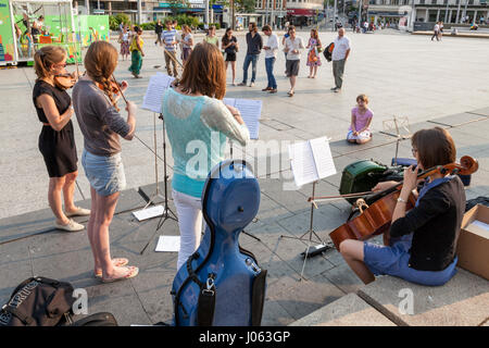 Musicisti musicista di strada: giovani donne buskers playing classical string quartet musica nel centro citta' di Nottingham, Inghilterra, Regno Unito Foto Stock