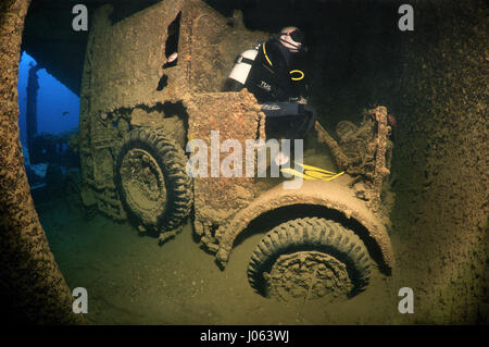 Un subacqueo si siede su un carrello ricreare ciò che avrebbe potuto essere. Lugubre foto subacquee mostrano all'interno del relitto della sunken British Guerra Mondiale due nave SS Thistlegorm il settantacinquesimo anniversario del suo affondamento. La serie di immagini che mostrano i resti arrugginiti della marina mercantile carico della nave che include motociclette, camion dell'esercito e di un aeromobile a elica. Altre foto mostrano come la vita di mare sono state che popolano il relitto. Foto Stock