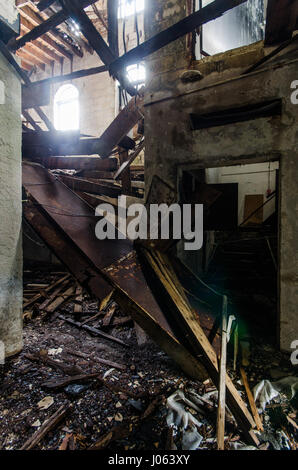 MIAMI, FLORIDA, Stati Uniti d'America: EERIE fotografie hanno rivelato il decadimento rimane del Miami chiesa che fu acquistato dal fondatore della supremazia nero Nazione di Yahweh il movimento che si è dichiarato il figlio di Dio e tracciati per uccidere americani bianchi. Da crolli di assi di legno a rifiuti ribaltato scale di graffiti e muri rivestiti della chiesa è un grido lontano dal suo apogeo. Altre riprese mostrano mobili oggetto di dumping in camere e una sedia solitario a sinistra in che cosa assomiglia ad una sala principale. La straordinaria sono state scattate in Little Haiti quartiere per un fotografo americano noto solo come Bullet. Per prendere la st Foto Stock