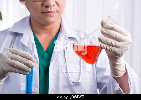 Scienziato maschio mantiene ed esaminare campioni Foto Stock