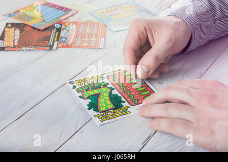 WROCLAW, Polonia - Marzo 28th, 2017: uomo polacco graffi lotteria gratta e vinci. Gratta e Vinci è una scheda piccola, dove le aree contengono informazioni nascoste Foto Stock