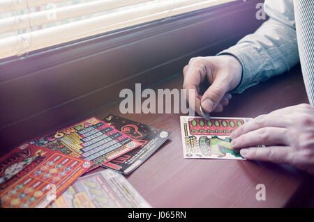 WROCLAW, Polonia - Marzo 28th, 2017: uomo polacco graffi lotteria gratta e vinci. Gratta e Vinci è una scheda piccola, dove le aree contengono informazioni nascoste Foto Stock