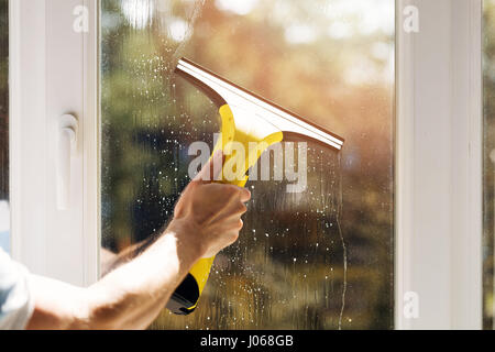 A mano nella finestra di pulizia con aspirapolvere Foto Stock