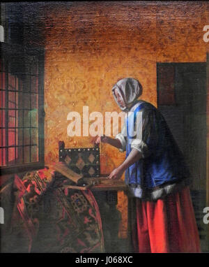 Die Goldwägerin di Pieter de Hooch (la pesatrice dell'oro) è un dipinto olandese del XVII secolo che raffigura una donna che pesa oro in un ambiente interno. La meticolosa attenzione dell'artista alla luce e allo spazio è un segno distintivo del suo lavoro, che riflette l'importanza della vita domestica e del commercio nella società olandese dell'epoca. Foto Stock