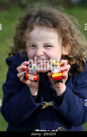 Una giovane ragazza nella foto al di fuori a giocare con lego in un parco a bognor regis, west sussex, Regno Unito. Foto Stock