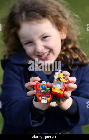 Una giovane ragazza nella foto al di fuori a giocare con Lego in un parco a Bognor Regis, West Sussex, Regno Unito. Foto Stock