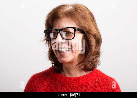 Senior donna in nero occhiali e il maglione, studio shot. Foto Stock