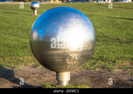 Sfera riflettente nel parco Foto Stock