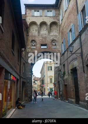 Persone su strada in mezzo a edifici, Siena, Toscana, Italia Foto Stock