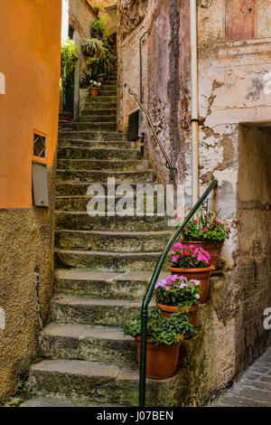 Una vecchia scala a chiocciola con vasi di fiori all'ingresso di un edificio storico in Cinque Terre, Italia Foto Stock