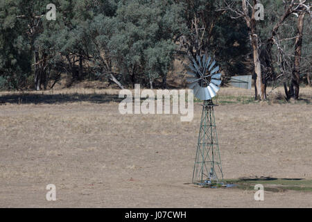 Una fotografia di un mulino a vento su una fattoria australiana. La fotografia è stata scattata su una calda estate mattina in Central West Wales. Foto Stock