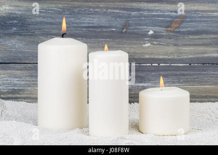 Una candela è accesa nelle tenebre e dà calore spirituale Foto Stock