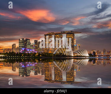 Tramonto sulla skyline di Singapore, con Marina Bay Sands e i giardini sulla baia riflettendo in Marina Bay. Foto Stock