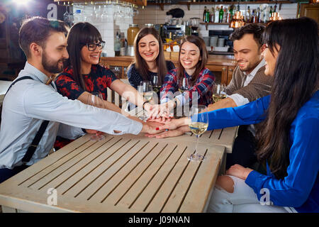 Gli amici mettendo le mani in segno di amicizia Foto Stock