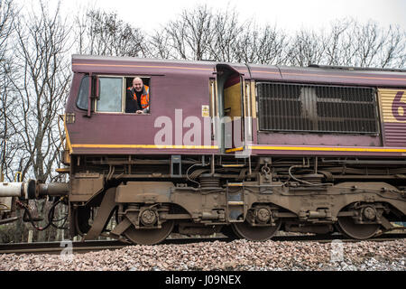 Conducente del treno di zavorra proteso al di fuori della finestra Foto Stock