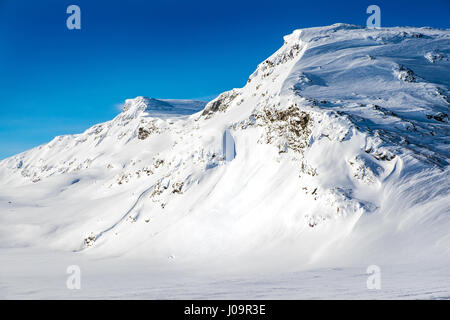 Coperta di neve montagna, cielo blu, Arctic Norvegia Foto Stock