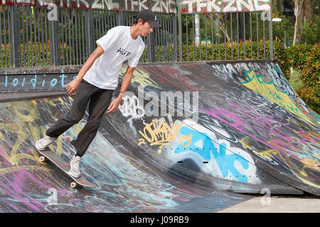 Giovane uomo asiatico lo skateboard in scape skate park, Singapore. Foto Stock