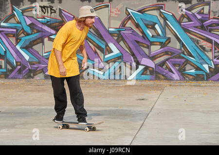 Giovane uomo caucasico skateboard in scape skate park, Singapore. Foto Stock