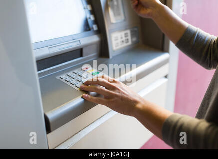 Stretta di mano immettendo il codice pin al bancomat Foto Stock