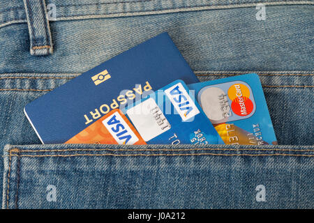 KIEV, UCRAINA - 09 agosto 2016: Blu passaporto biometrico con tre carte di credito Visa e MasterCard, nella tasca posteriore dei jeans blu closeup. Foto Stock