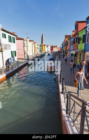 BURANO, Italia - 22 settembre 2016: turistico non riconosciuto a piedi lungo il canale tipico con barche ormeggiate e torre pendente. Burano è un'isola nelle vene Foto Stock