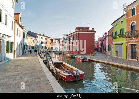 BURANO, Italia - 22 settembre 2016: la gente a piedi lungo il canale con le barche e case colorate. Burano è un'isola conosciuta per le sue opere in pizzo e luminosamente Foto Stock