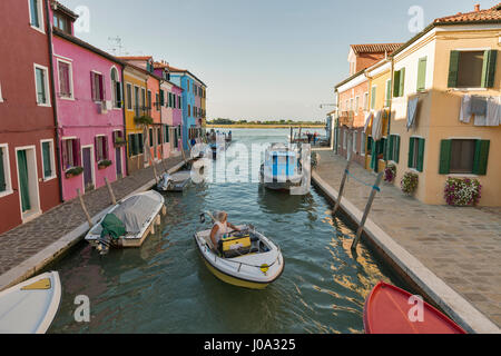 BURANO, Italia - 22 settembre 2016: la gente a piedi lungo il canale con le barche e case colorate. Burano è un'isola conosciuta per le sue opere in pizzo e luminosamente Foto Stock