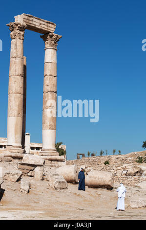 Uomini musulmani davanti alle rovine del tempio di Ercole, la più importante struttura romana nella cittadella di Amman, il sito archeologico Foto Stock