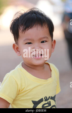 Bambini asiatici di un ragazzo in una maglietta gialla e sorridente felicemente,concetto di buona salute dell'infanzia. Foto Stock