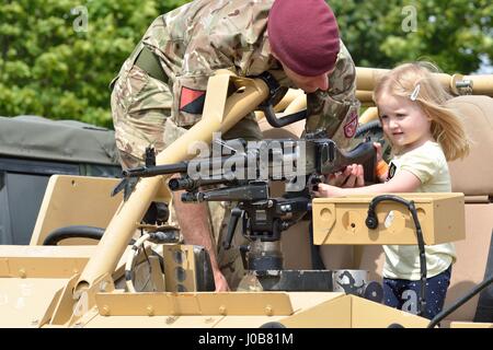 Tatuaggio militare COLCHESTER ESSEX REGNO UNITO 8 Luglio 2014: piccola ragazza essendo mostrata la pistola dal soldato Foto Stock