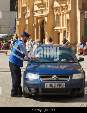 Parcheggio enforcement officer dando fuori un biglietto. Foto Stock