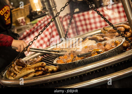 Il bratwurst sauages essendo cotti su una griglia di fiamma in un tedesco Street Market si trova a Liverpool, in Inghilterra Foto Stock